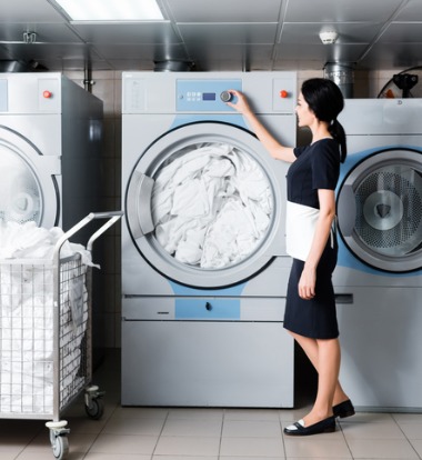 Woman Examining Laundry Machines for Hotels