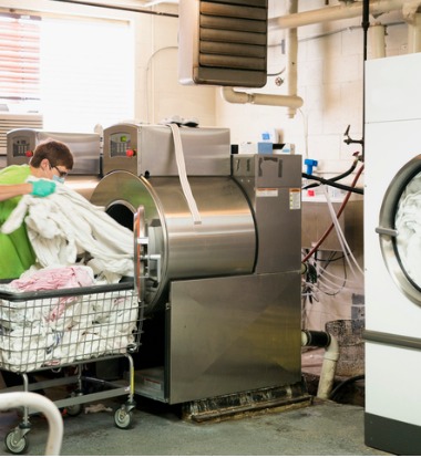 Woman Loading Commercial Washers for Healthcare