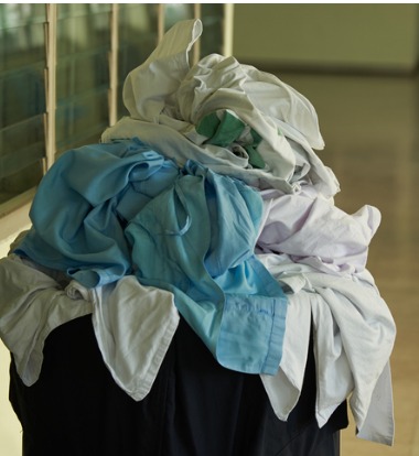 Laundry Laud Waiting to be Thrown into Industrial Washers for Hospitals